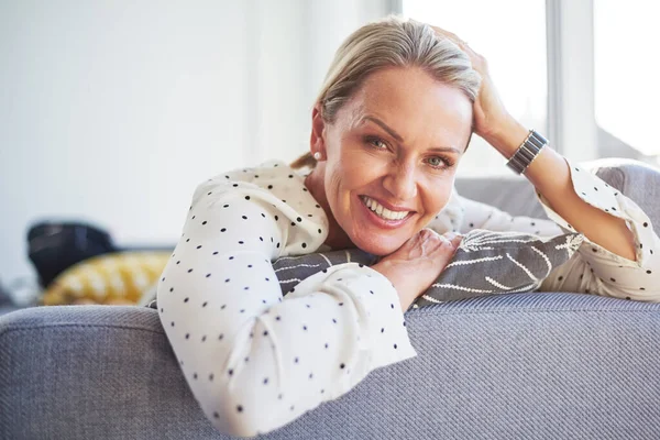 stock image Im not getting off this couch today. a happy mature woman relaxing on the sofa at home