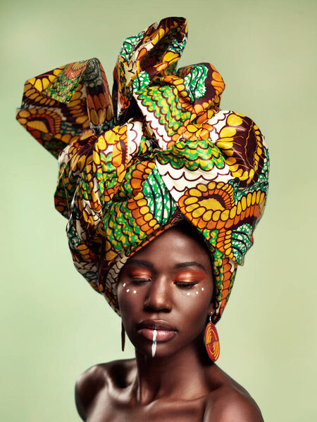 Beauty, black woman and queen makeup with African head wrap and pride with fashion. Isolated, green background and young female person with a traditional hair scarf with confidence and culture.
