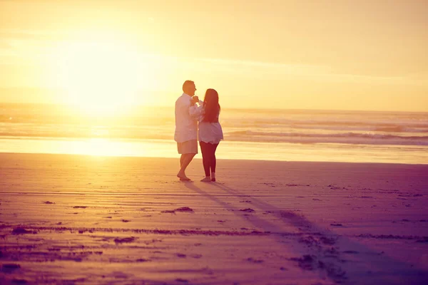 太陽の下で踊る 日没時にビーチで踊る愛情のある成熟したカップルの完全な長さのショット — ストック写真