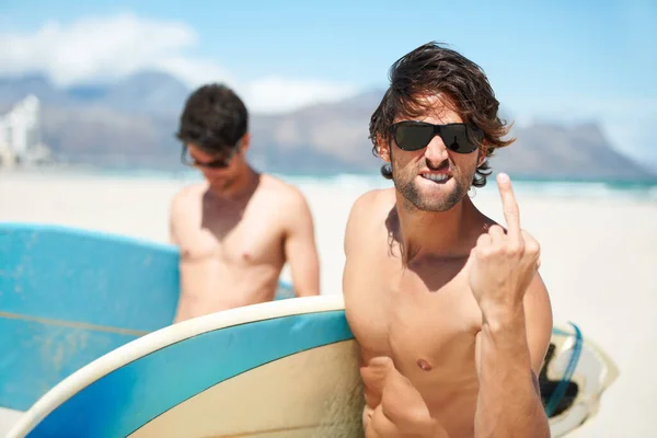 夏休みや海外旅行のために一緒に屋外で一緒にビーチ 中指や男性サーフィン友達 サーフィン 海や海岸でサングラスや友人の絆で若い男性サーファーと失礼な — ストック写真