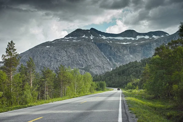 stock image Road, mountain and travel landscape, trees and nature with direction and destination with asphalt and highway. Environment, street and location with journey and traveling view outdoor with horizon.