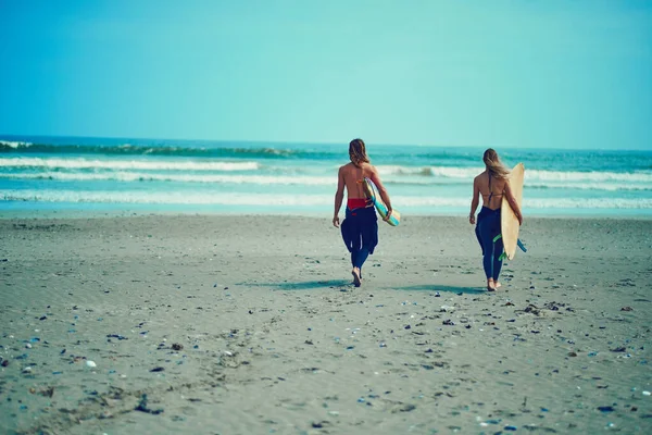 退屈してるだけだ 若いカップルがサーフボードを持ってビーチを歩いていて — ストック写真