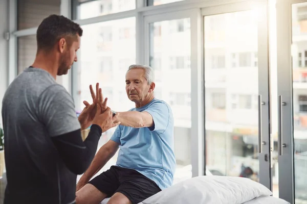 Han Får Den Hjälpande Hand Han Behöver Ung Manlig Fysioterapeut — Stockfoto