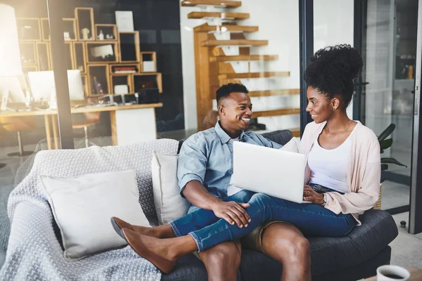 stock image Its what they do on their weekends. a happy young couple using a laptop together on the sofa at home