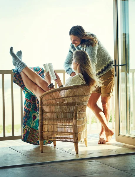 stock image Theyve mastered the art of relaxation. a young couple reading a book together while relaxing on the balcony