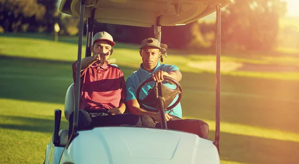 我们最喜欢的交通方式 两个高尔夫球手骑在高尔夫球场的推车上 — 图库照片
