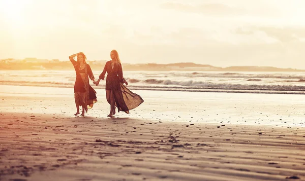 あなたの心があなたを連れて行くところへ 2人の若い女性が日没時にビーチで過ごし — ストック写真