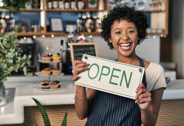 Happy woman, open sign and portrait of waitress at cafe in small business, morning or ready to serve. Female person, restaurant owner or server holding board for coffee shop or cafeteria opening.