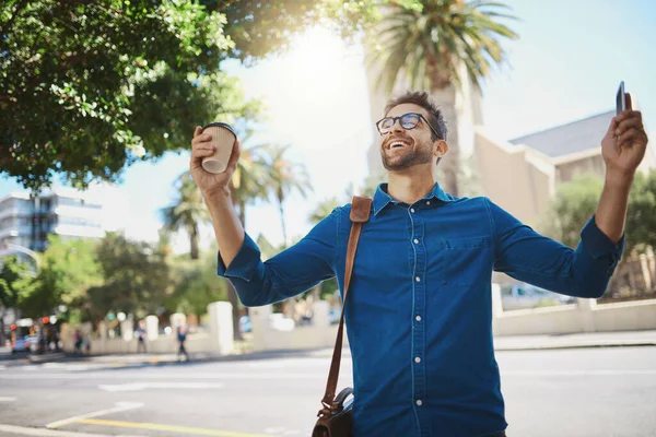 Stock image I got the job. a man looking cheerful while holding a coffee and his cellphone