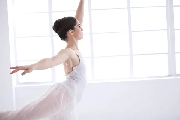 stock image Dance, ballet and window with woman in studio for balance, elegant and performance. Artist, theatre and training with female ballerina dancing in class for competition, freedom and commitment.