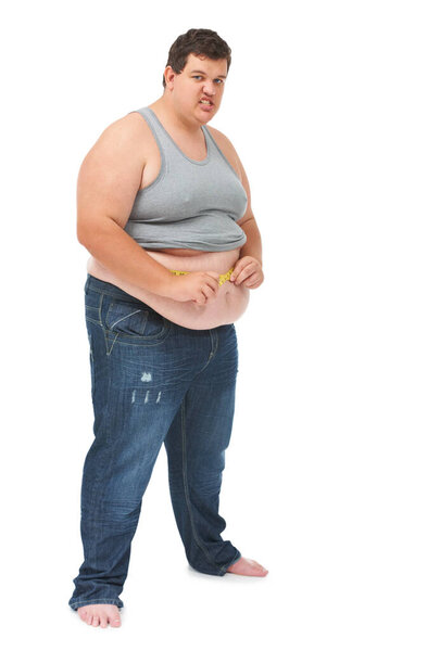 Obesity, tape measure on abdomen and portrait of angry man checking size, body health and isolated on white background. Frustrated male, measuring stomach and weight loss progress on studio backdrop