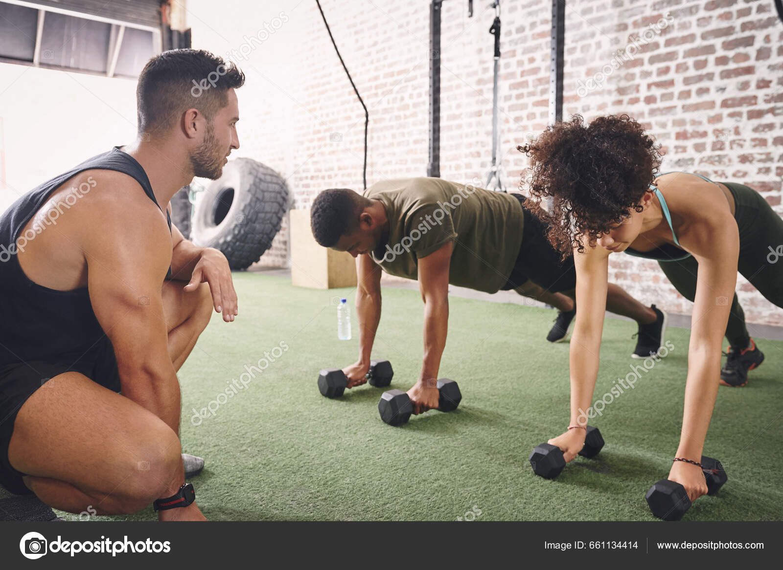 Group, workout and dumbbell push up at gym for muscle, power or strength.  Teamwork, sports or energy of people, athletes or bodybuilder friends  exercise or training at fitness center for healthcare. Stock