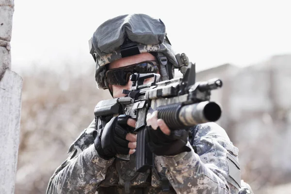 任務のための軍隊で銃を持つ男 防衛のための銃器で銃撃 危険または暴力のための戦場でライフルを持つ軍隊 英雄と兵士 — ストック写真