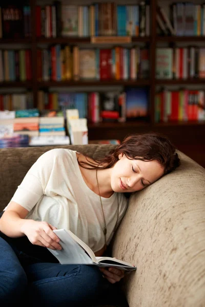 書棚でリラックスしながら文学のためのソファの上で本を読んでいる穏やかな 図書館や女性 本屋やお店でソファで幻想的な物語や小説を楽しんで笑顔で休息 幸せと女性の人 — ストック写真