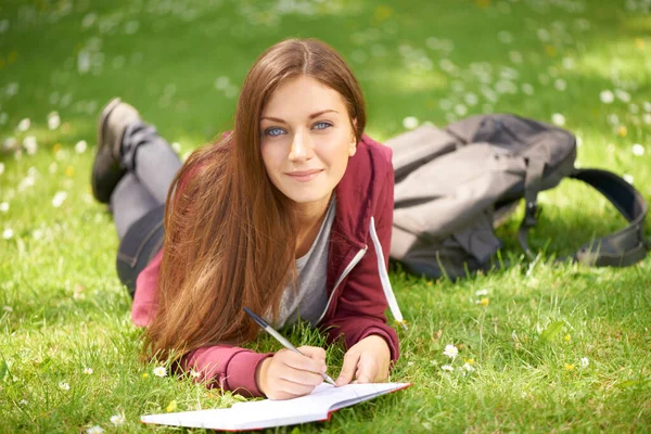 在大学 校园或公园学习的妇女 学生和草类 用于写作 肖像或规划 在阳光下 在大学草坪上读书写字 学习或头脑风暴 — 图库照片#