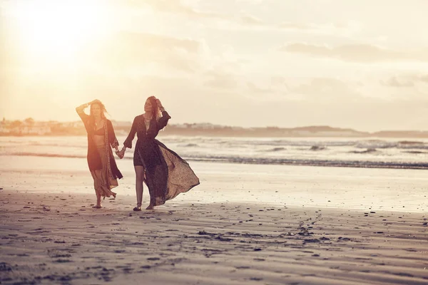 私たちは太陽のそばに住んでいる 2人の若い女性が日没時にビーチで過ごし — ストック写真