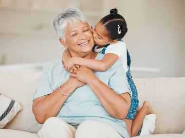 Aile, kız sarılıp büyükanneyi mutlulukla öpmek, evde sevgiyle gülümsemek. Oturma odasında yaşlı kadın ve çocuğa sevgi, ilgi ve güven, sarılma ve mutluluk..