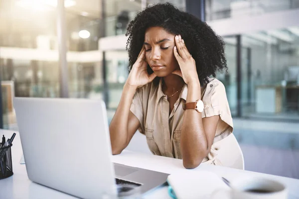 Every job has its stressful moments. a young businesswoman looking stressed at her desk in a modern office