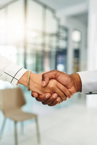 Stock image Heres to building a better business together. Closeup shot of two businesspeople shaking hands in an office