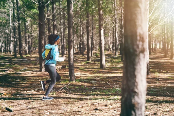 继续走一个年轻的女运动员在树林里慢跑时拍的全景照片 — 图库照片