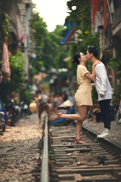 キスするのにふさわしい時が来た ベトナムの街中の電車の線路でロマンチックな瞬間を共有する若いカップルは — ストック写真