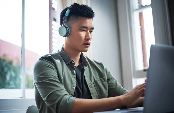 stock image His designs are carefully thought out. a handsome young man listening to music while working from home