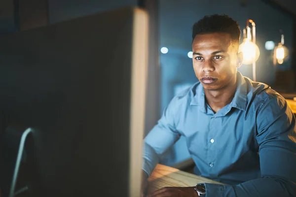 Stock image Hes one focused individual. a handsome young businessman working late at night in a modern office