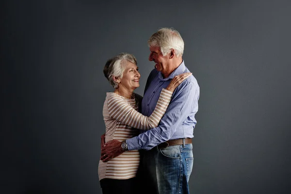 stock image Ill never let you go. Studio shot of an affectionate senior couple posing against a grey background