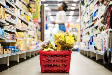 Alışveriş sepeti, çiçekler ve marketin zemininde tanıtım, satış ya da kadın hediye olarak müşteri deneyimi. Plastik konteynır, süpermarket ve perakende, fabrika ve alışveriş merkezi.