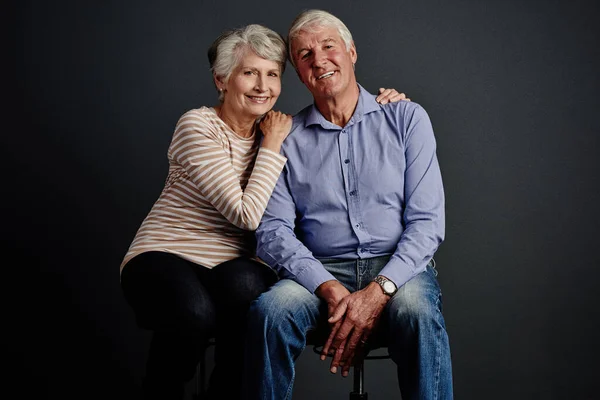 stock image Our love grows stronger with time. Studio portrait of an affectionate senior couple posing against a grey background