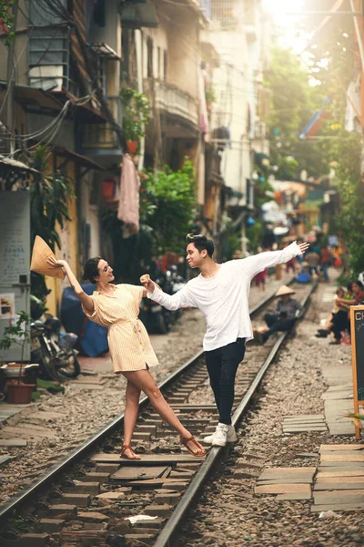 お前を生かしておくように愛し合うんだ ベトナムの街の電車の線路で踊っている若いカップルが — ストック写真