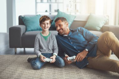 Sen ve ben baba. Neşeli küçük bir çocuk ve babası gün içinde evde yerde otururken televizyonda oyun oynuyorlar.