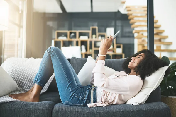 stock image Up close and personal with her favourite series. an attractive young woman relaxing at home