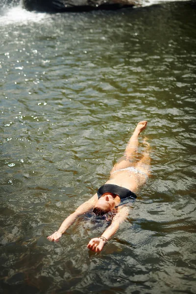これが私がリラックスする方法です 屋外で一日中一人で小川で泳いでいる認識できない女性の完全な長さのショット — ストック写真