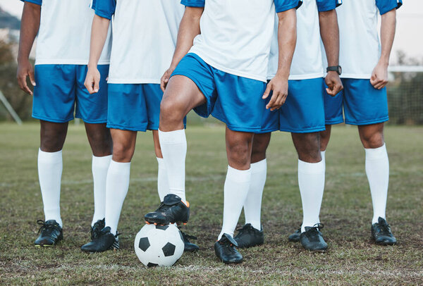 Soccer ball, sports group and feet of a team on a field to start fitness training or game outdoor. Football player, club and legs of athlete men together for sport competition, exercise and challenge.