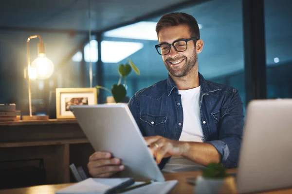 stock image On the road to success. a young handsome businessman working late at night on his tablet in a modern office