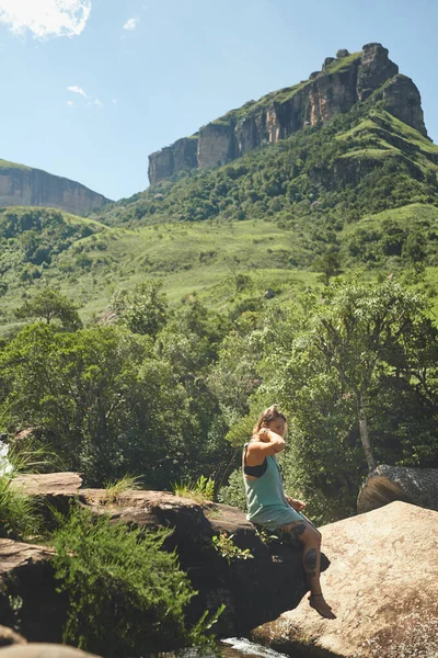 私は自然を思い出すために行く 屋外で一日中岩の端に一人で座って魅力的な若い女性の完全な長さのショット — ストック写真