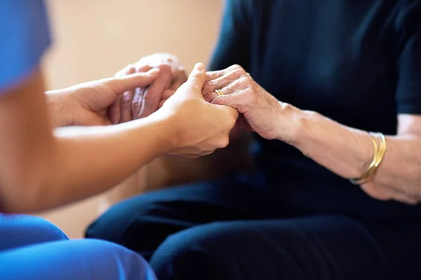 stock image Doctor, senior people and holding hands for support, healthcare service and medical, advice and empathy. Professional nurse, helping and retirement nursing for elderly person in together sign closeup.