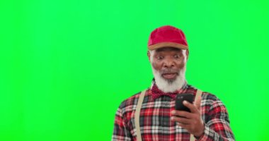 Telefon, wow ve kazanan yaşlı siyah bir adamla stüdyoda yeşil ekranda bir duyuru yapıyor. Portre, temas ve cep telefonu ile mutlu bir yetişkin erkek iyi bir haber bildirimi okuyor..