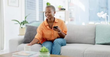 Kahve, rahatlama ve evde oturma odasındaki kanepede oturan siyah bir kadın, mesajlaşma ya da sosyal medya. Çay, cep telefonu ve internet gezisi için cep telefonlu mutlu bir kadın.