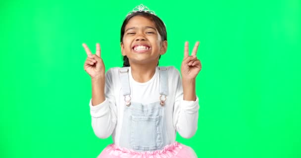 小さな女の子 王女とスタジオの背景に喜びの幸福の緑の画面上の平和の兆候と笑顔 幸せな愛らしい子供や子供の肖像画は モックアップで平和な手の兆候を示しています — ストック動画