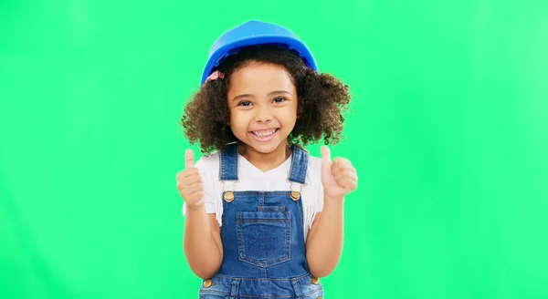 Little girl, thumbs up and construction with safety helmet on green screen for good job against a studio background. Portrait of architect kid showing thumb emoji, yes or like for success on mockup.
