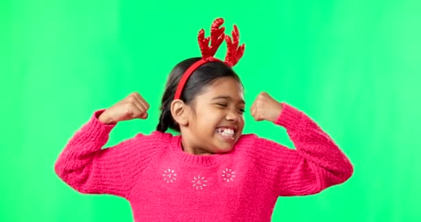 绿色荧幕上的儿童肖像 圣诞节和鹿角为动机而弯曲强壮的肌肉或胳膊 带着驯鹿头带 在工作室背景上当着一个女孩的面微笑 庆祝节日 — 图库视频影像