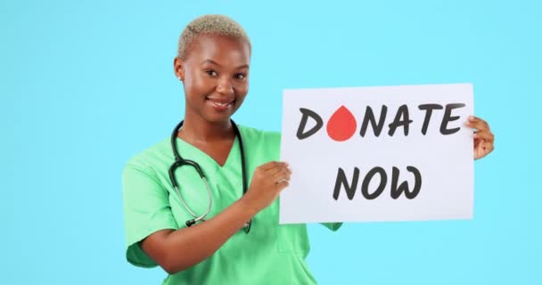 ポスター付きの顔 黒い女性 医師は 青いスタジオの背景に対して今と幸せを寄付します サイン 血滴と情報のための紙を持つ肖像画 女性の人と医療専門家 — ストック動画