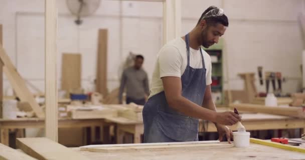 木匠和一个男人在车间里用油漆刷制造工艺 非洲男性 在木工工厂为创意家具项目 设计和生产作画时重点关注 — 图库视频影像