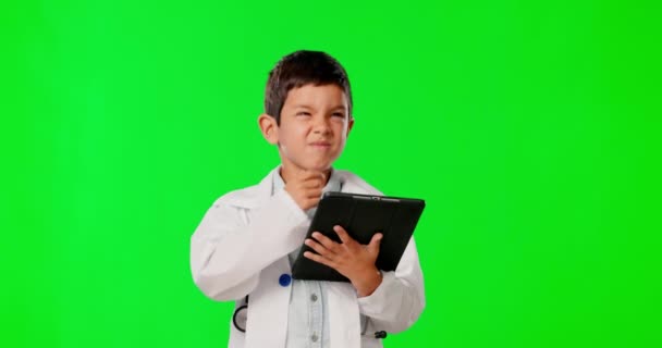 スタジオの背景に隔離された緑のスクリーンで考えること タブレットと子供の医者 閲覧とモックアップとインターネットのための技術を持つヘルスケアの専門家であるふり少年 — ストック動画