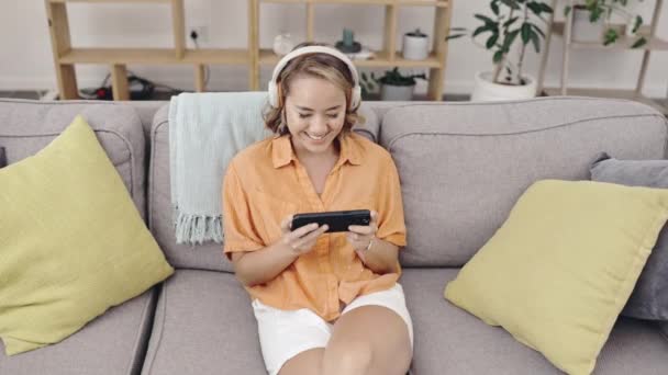Vista Superior Mujer Asiática Sofá Auriculares Con Teléfono Celular Streaming — Vídeos de Stock