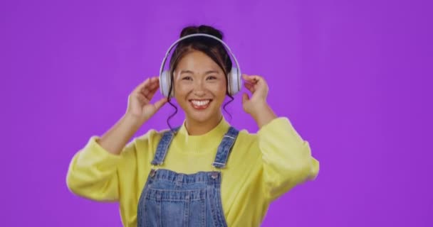 舞蹈和亚洲女人面对快乐 自由和积极的能量与耳机 快乐的舞曲 根茨的人和年轻的女学生在一个与世隔绝的工作室里听着网络音频 — 图库视频影像