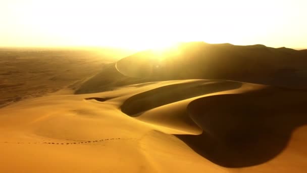 目的地 自由または夏の旅行のための無人機で日没時の人の旅行 砂漠とシルエット 旅行やナミビアの休暇中の砂丘の地平線に男との旅 — ストック動画
