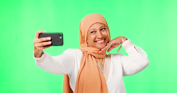 イスラム教徒の女性 自撮りやキスで緑の画面 スタジオの背景やソーシャルメディアで幸せなモックアップ 女性のイスラム教徒のモデル 影響力のある 絵文字やモックアップのプロフィール写真と写真 — ストック動画
